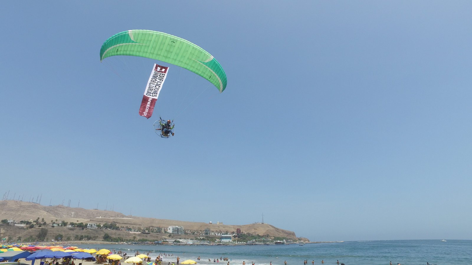 Parapente mostrando una pancarta publicitaria en el cielo