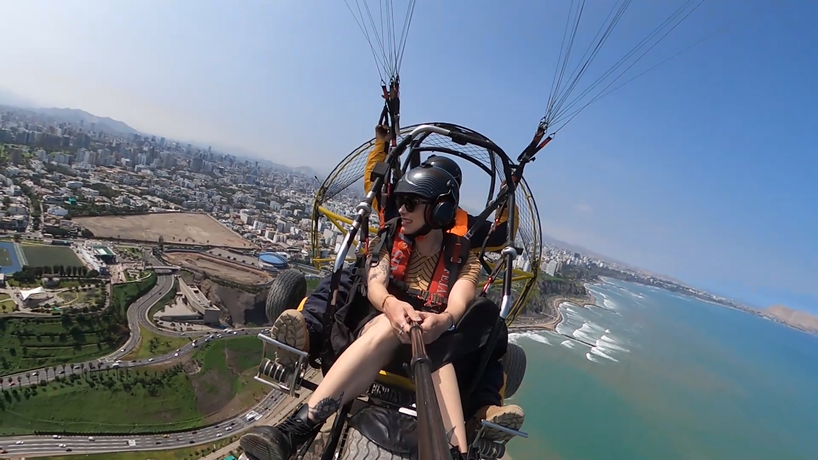 Persona volando en parapente sobre la Costa Verde de Lima